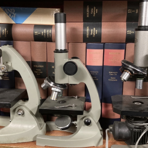 Vintage grey laboratory microscope – retro scientific prop